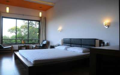 A hotel room with a double bed and a glass window