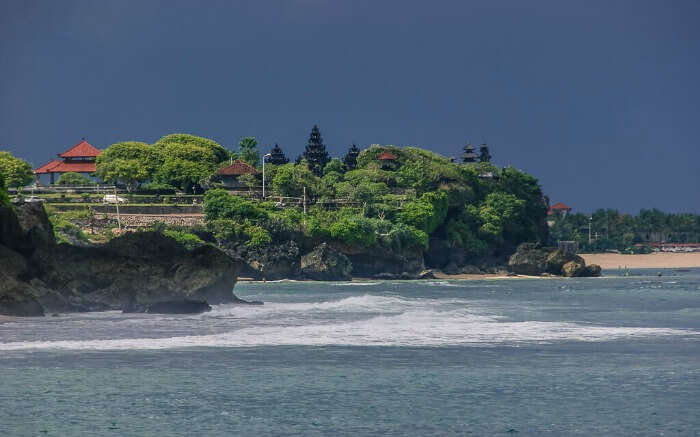 A temple at a green and beautiful cliff overlooking an ocean 