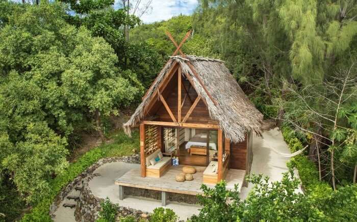 A thatched bungalow surrounded by lush greenery in Tsarabanjina in Madagascar