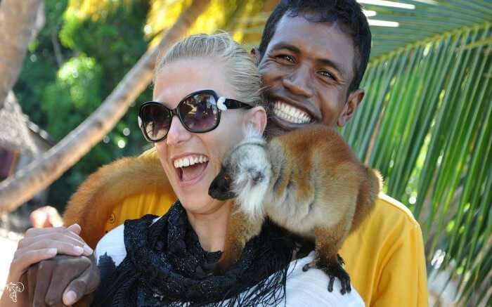 A traveler playing with a lemur in Lokobe Nature Reserve in Madagascar