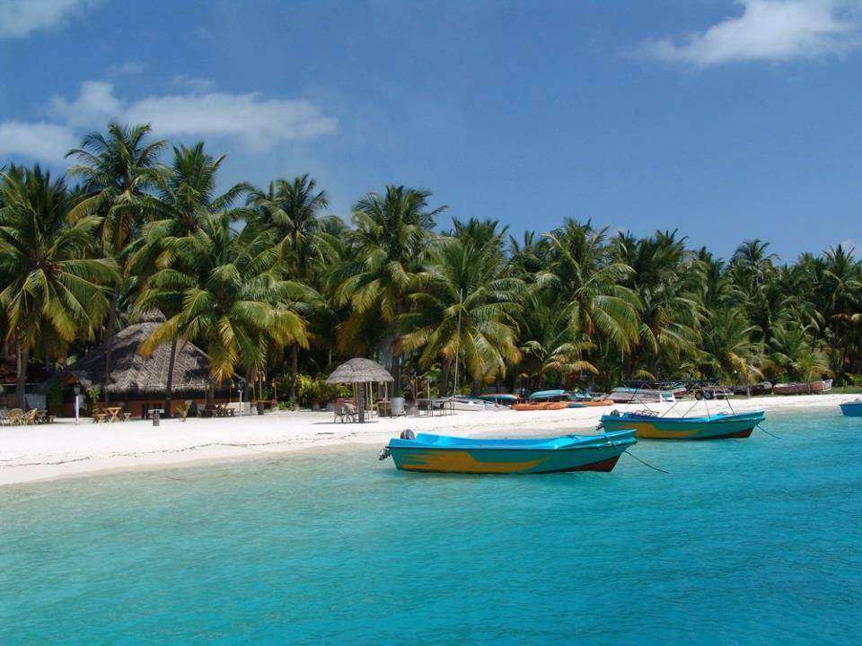 लक्षद्वीप पर्यटन स्थल बंगाराम द्वीप नीले पानी के किनारे दो नावें