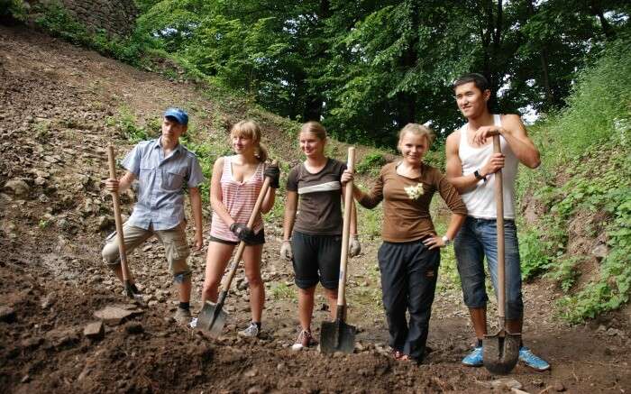 People cleaning up the surroundings while on a volunteering trip in Europe