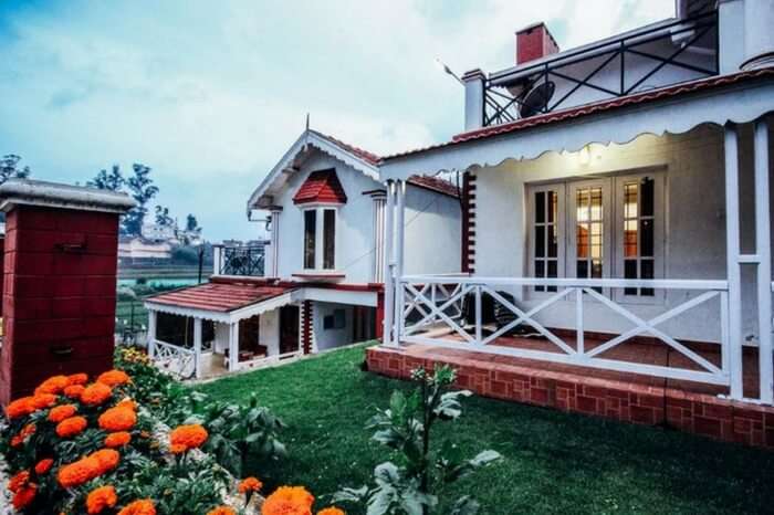 Balcony with garden view of one of the villas of Pine View Stay in Ooty