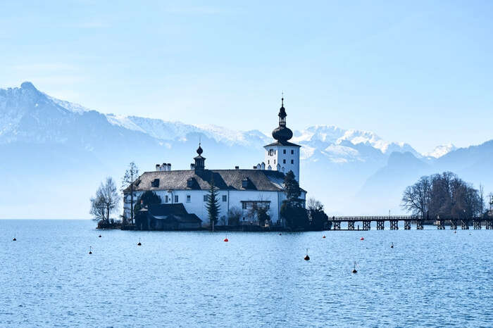 Ort Castle in Gmunden with lake around and Alps in the backdrop