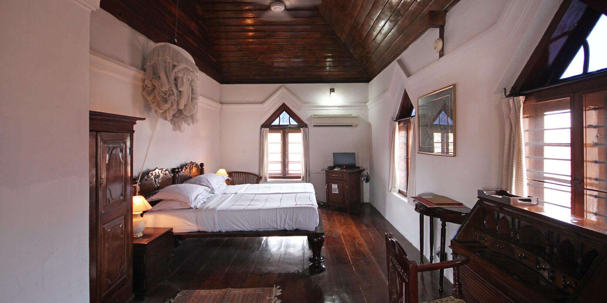 An old style hotel room in Kerala with a bed inside