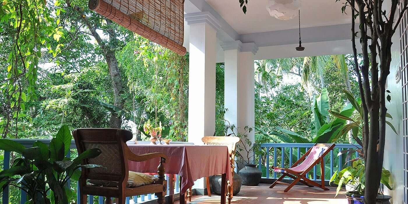 a table and a chair on a porch of a hotel