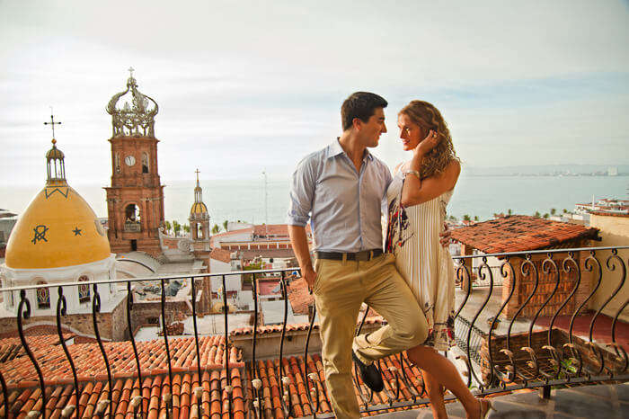 A couple on their honeymoon in Mexico share a romantic moment at a church in Puerto Vallarta old town