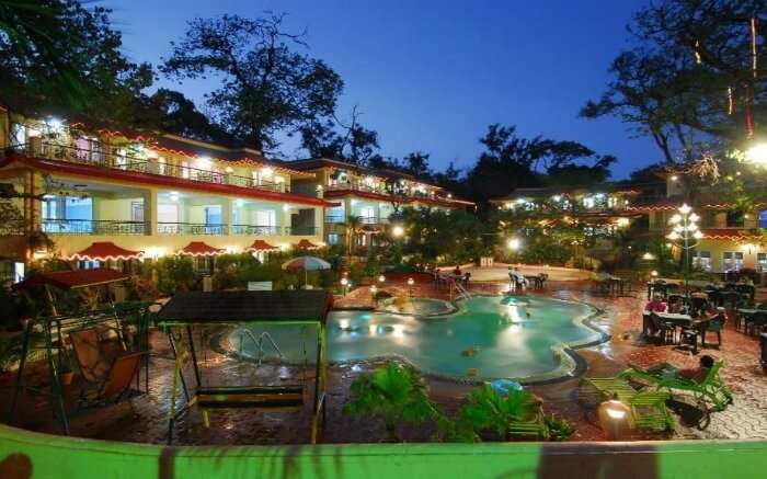 A well lit resort with swimming pool 