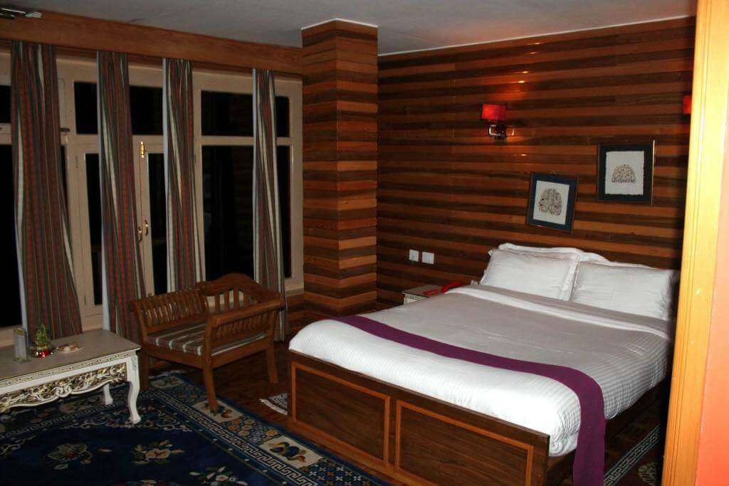 a room with wooden decor and a big bed and sofa