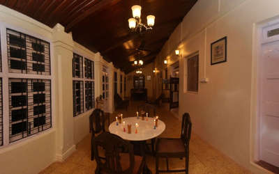 Corridor of a colonial style resort with a table and chairs 