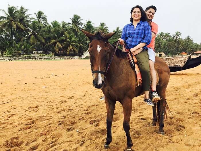 aarti and revan riding horse on beach in kovalam, kerala