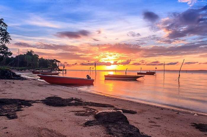 enjoy a riveting sunset at nelayan beach