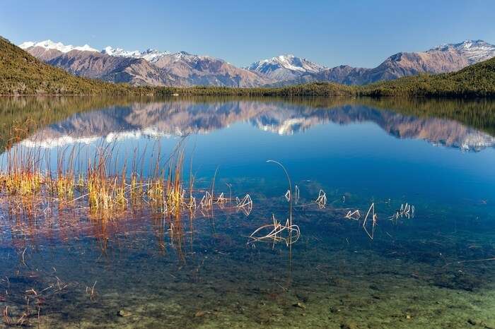 a reflection of snowclad mountains on Rara Lake