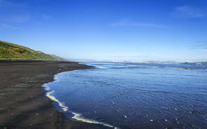 The black sand by the Kariotahi Beach in Auckland 