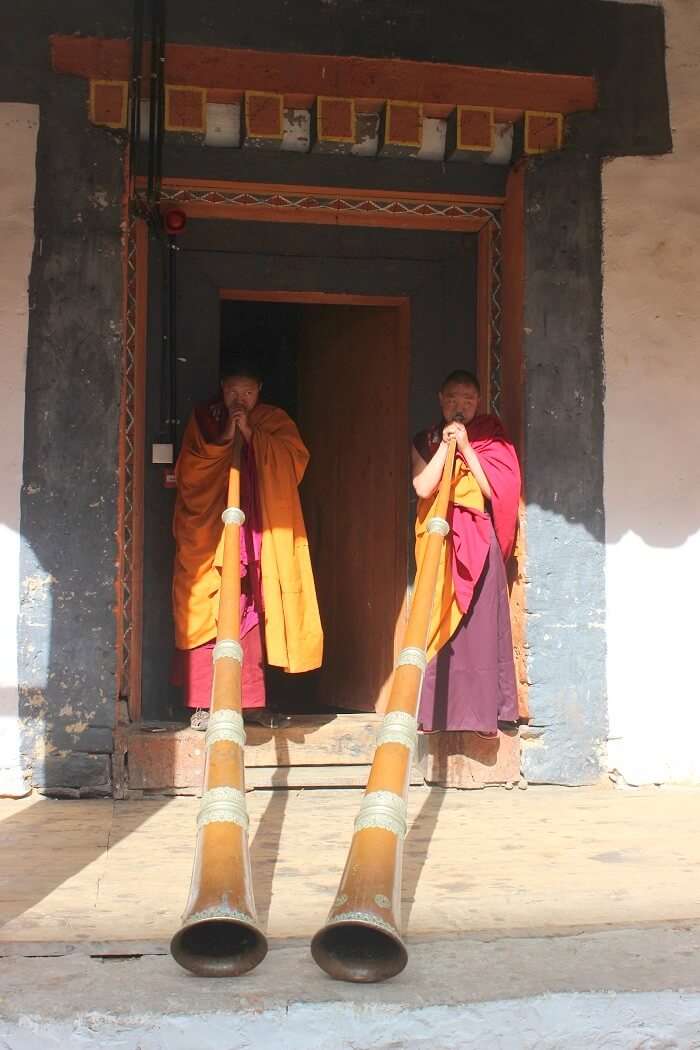 monks with trumpets in bhutan