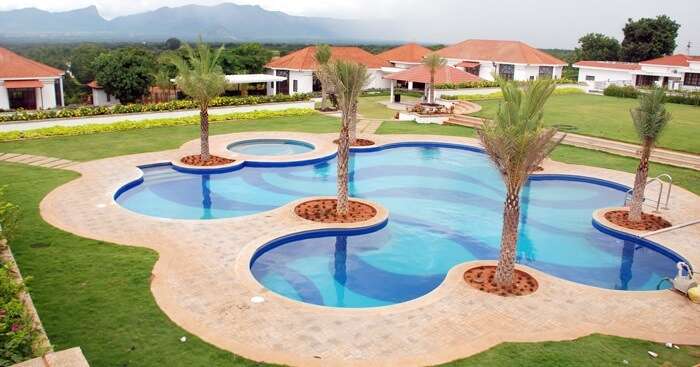 A snap of the swimming pool and the surrounding cottages at the Bungalow Club Resort in Coimbatore