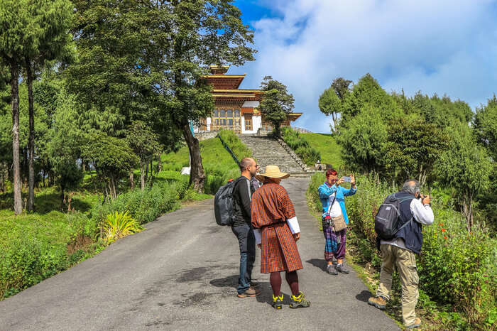 foreigners with a Bhutanese man outside a temple