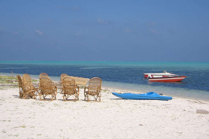 Bamboo chairs and a surfing board on the beach of Minicoy