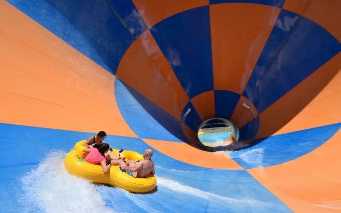 three people enjoying in a water swing in Wet n Wild theme park 