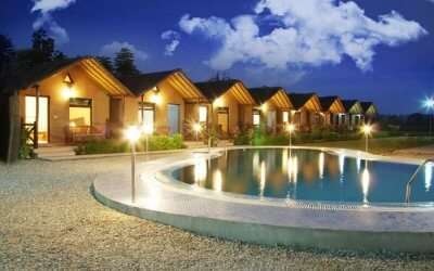 wooden style well lit resort with a small swimming pool