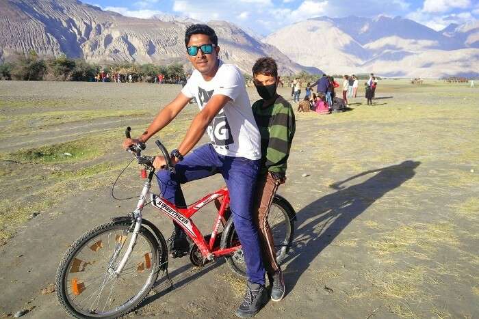 ninad riding bicycle with a local in ladakh