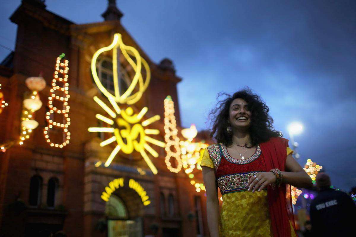 a woman standing outside a temple in London during Diwali