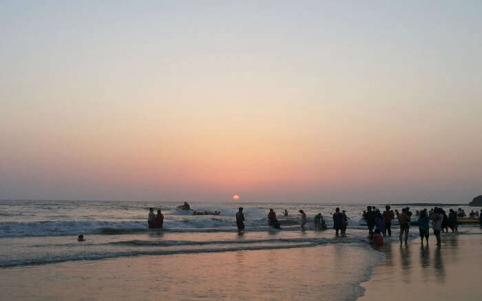 people at a beach during sunset 