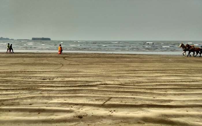 people walking on a sandy beach 