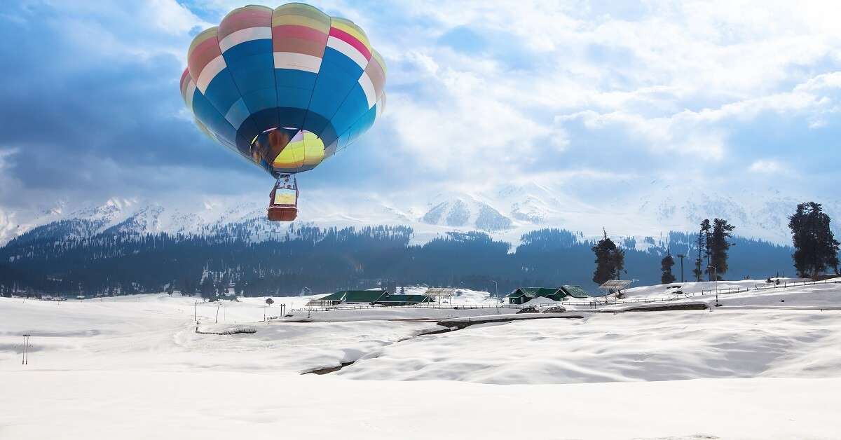 A hot air balloon flying over a village in Gulmarg in Kashmir