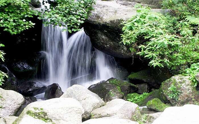 A small waterfall among huge boulders 