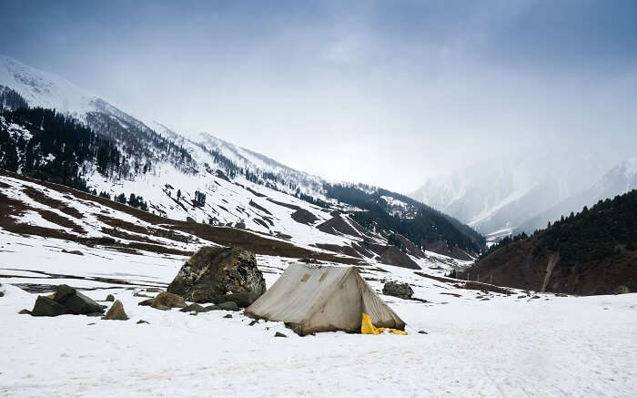A tent in the middle of snow mountains during winter in Kashmir 