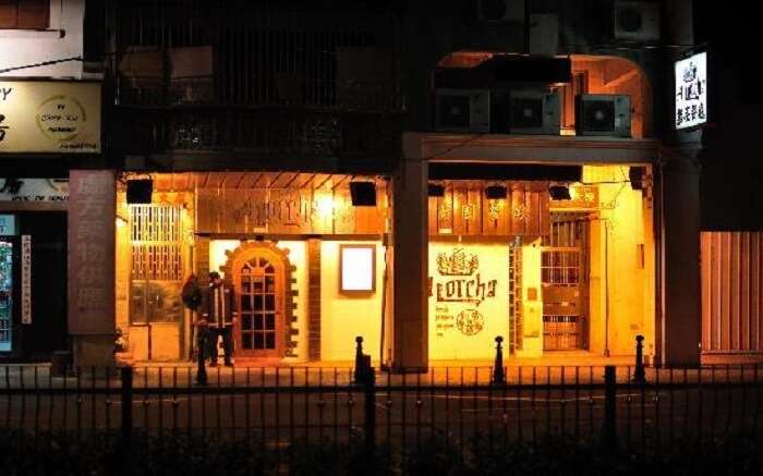 A well lit gate of a cafe at night