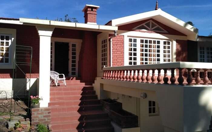 A white chair in the verandah of the red cottage