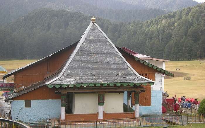 An old temple overlooking thick deodar forest 