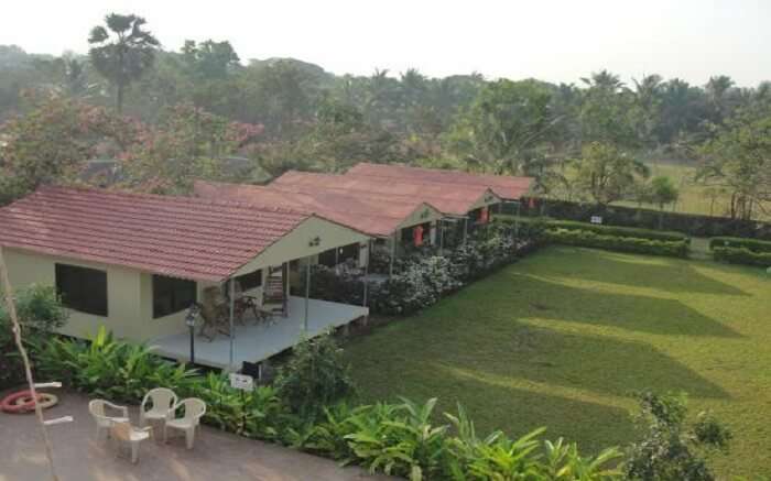 Four cottages in a row with wide porch and a huge lawn 