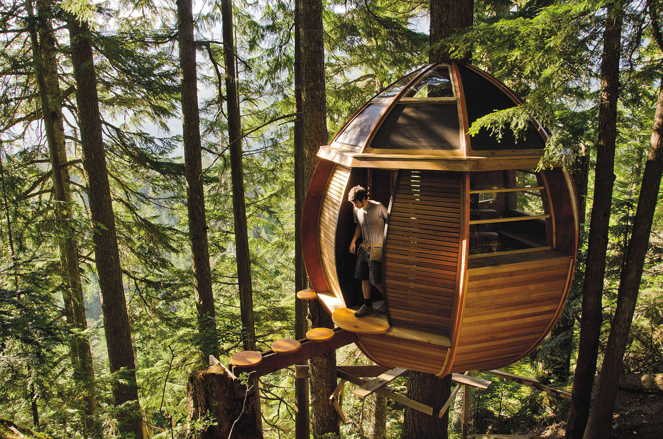 A man coming out of the Hemloft Treehouse in Whistler in Canada