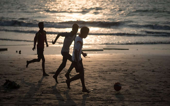 Three kids playing on a beach in evening 