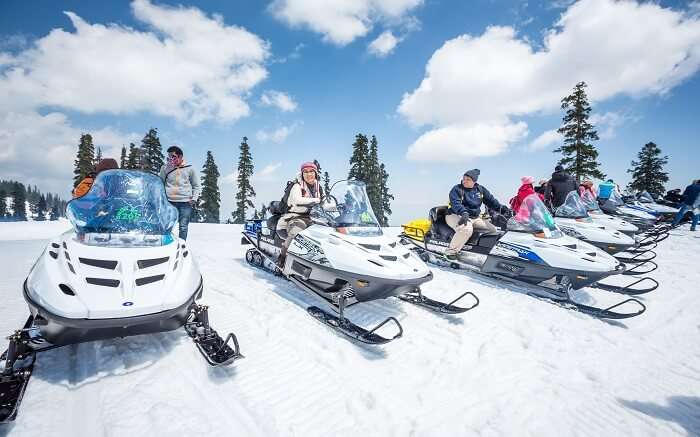 Tourists riding snow scooter during winter in Kashmir 