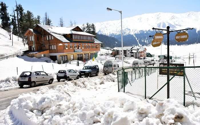 Vehicles parked outside a resort in Kashmir with snow all around