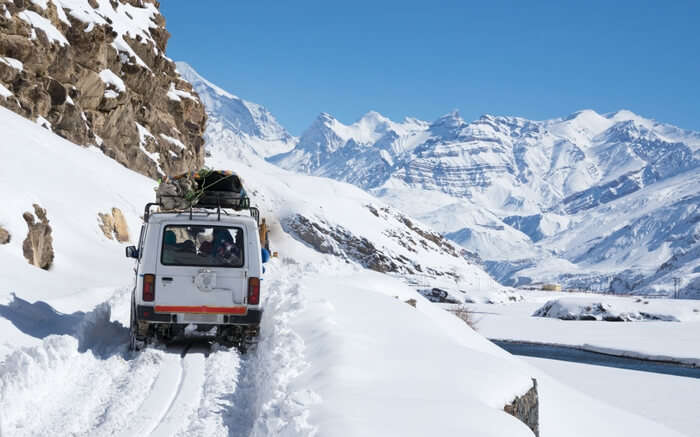 A jeep moving on a road covered in snow in Spiti during winter