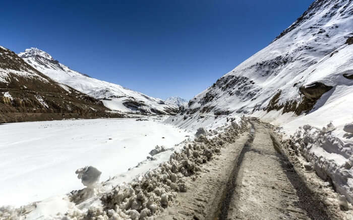 A sloppy road covered in snow leading to the Spiti valley