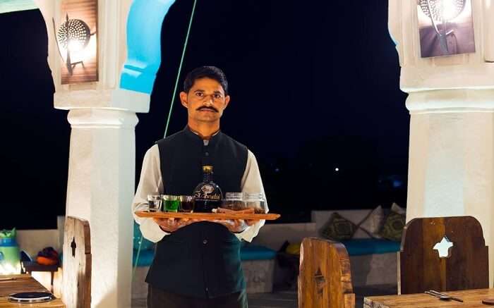 Staff holding tray for local liquor tasting 