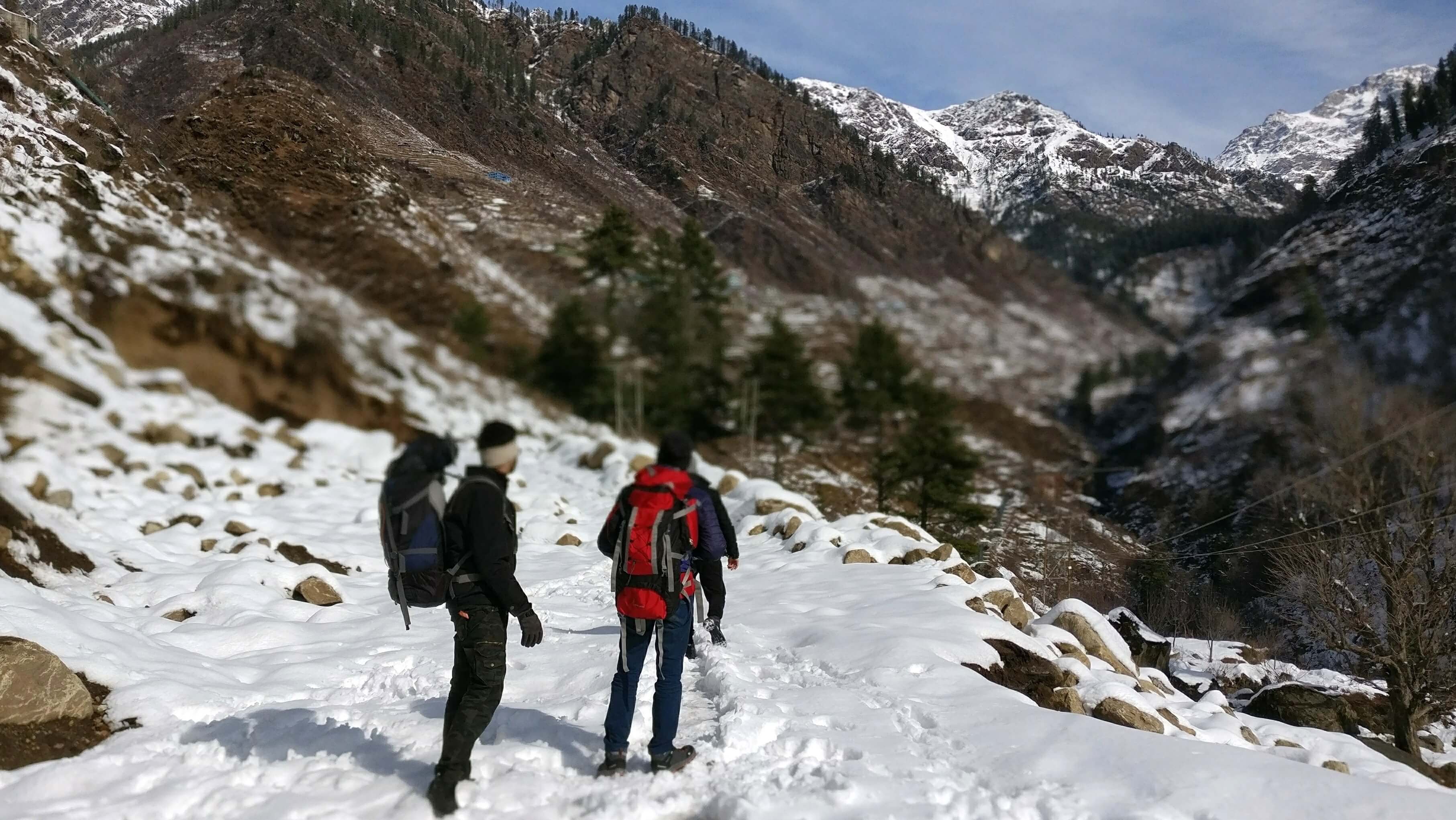 two men walking in snow in mountains