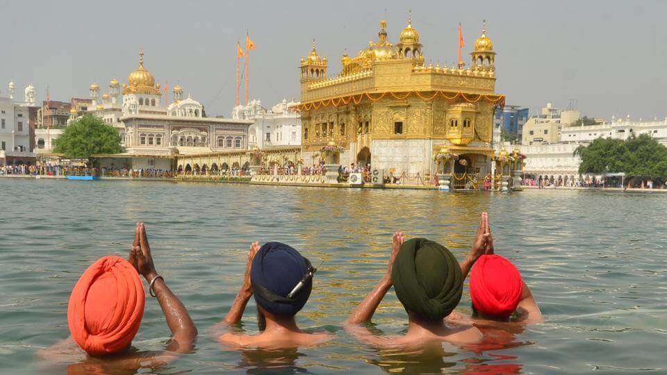 4 men praying in Golden Temple