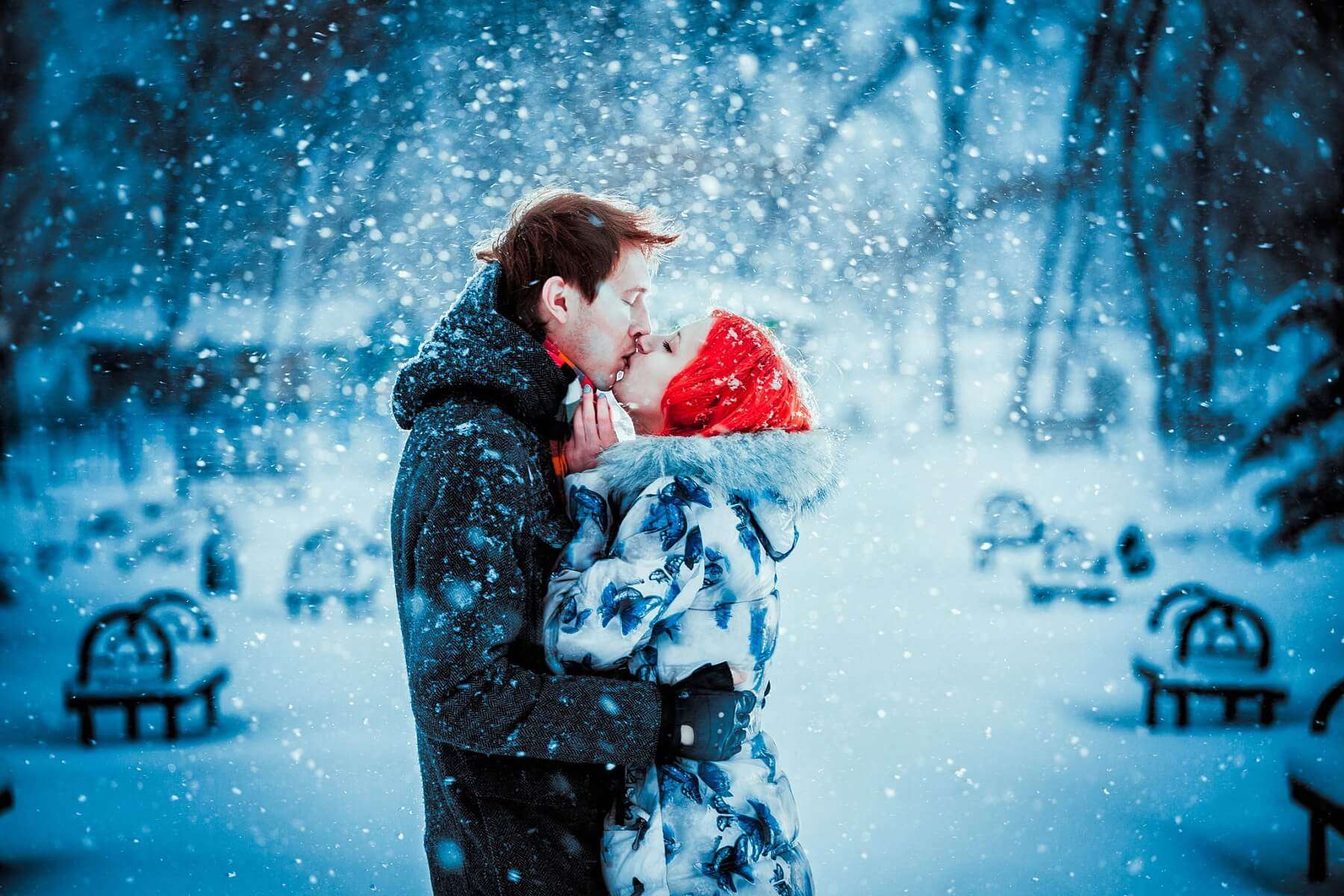 a couple kissing in snowfall