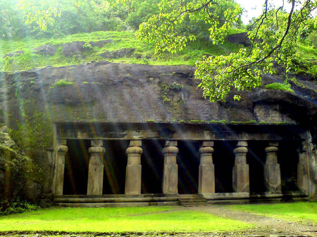 Elephanta caves covered in moss and green trees
