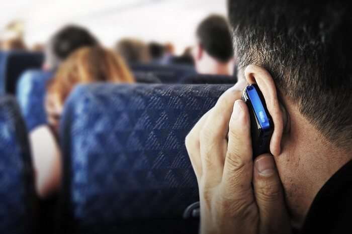 a man taking a call on a flight