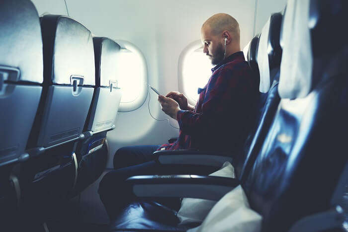 a man listening to music on a flight
