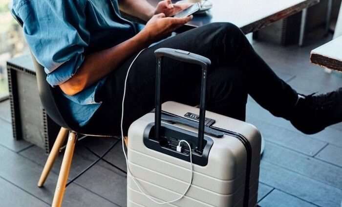 traveler charging phone from smart luggage