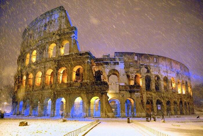 The ancient Colosseum is seen during an heavy snowfall late in the night in Rome